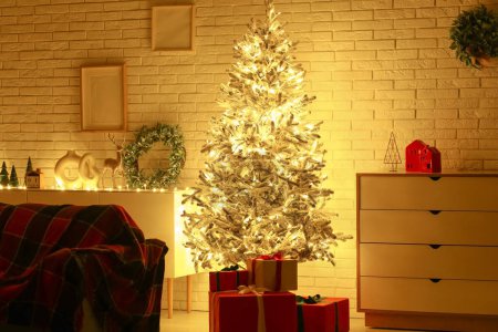 Photo for Interior of stylish living room with beautiful Christmas tree and gift boxes at night - Royalty Free Image