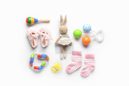 Foto de Juguete de punto con calcetines de bebé y sonajeros sobre fondo blanco - Imagen libre de derechos