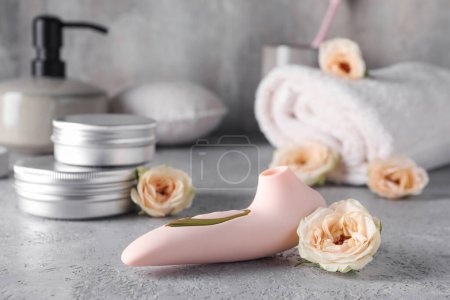 Photo for Vibrator with flowers on grunge table, closeup - Royalty Free Image