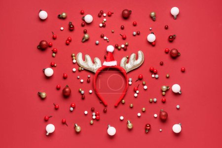 Téléchargez les photos : Mignonnes cornes de rennes avec décorations de Noël sur fond rouge - en image libre de droit