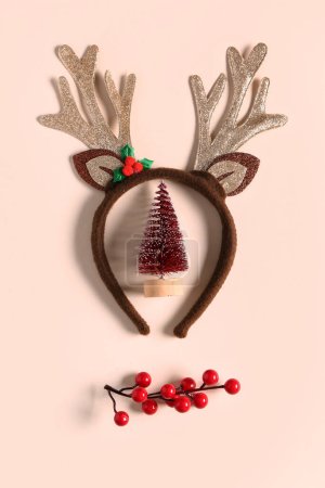 Téléchargez les photos : Cornes de renne avec branche de viorne et jouet de sapin de Noël sur fond beige - en image libre de droit