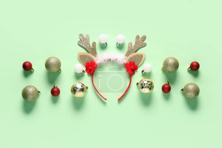 Téléchargez les photos : Cornes de rennes de Noël avec boules sur fond vert - en image libre de droit