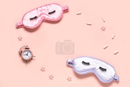 Téléchargez les photos : Cadre composé de masques de sommeil, réveil et pilules sur fond rose - en image libre de droit