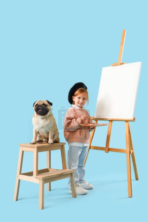 Téléchargez les photos : Petit artiste avec peinture mignon chiot carlin sur fond bleu - en image libre de droit