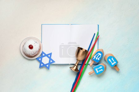 Photo for Hanukkah composition with open book, donut, candles and dreidels on light blue background - Royalty Free Image