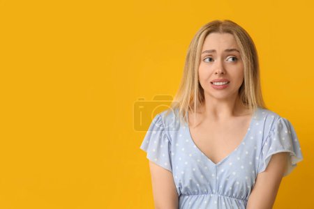 Photo for Embarrassed young woman on yellow background - Royalty Free Image