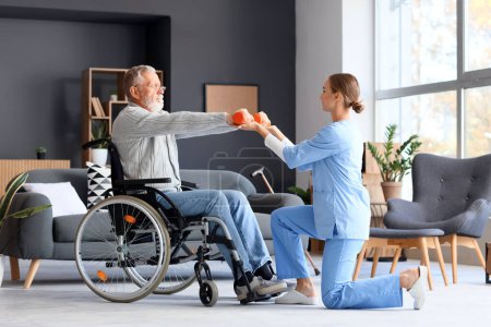 Photo for Senior man in wheelchair with dumbbells and nurse training at home - Royalty Free Image