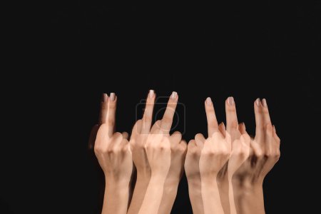 Foto de Foto estroboscópica de una mujer en movimiento mostrando el dedo medio sobre fondo oscuro - Imagen libre de derechos