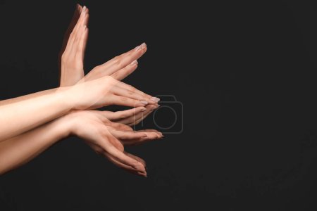 Foto de Foto estroboscópica de manos femeninas en movimiento sobre fondo negro - Imagen libre de derechos