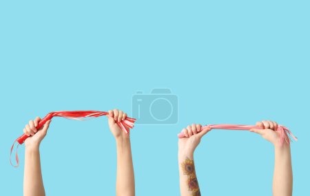 Foto de Las manos femeninas con látigos de sex shop sobre fondo de color - Imagen libre de derechos