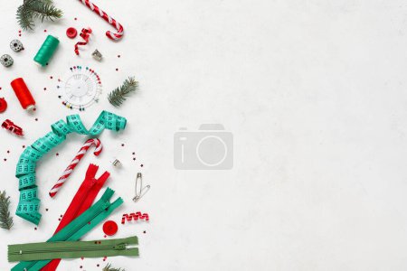 Foto de Composición con accesorios de costura y decoraciones navideñas sobre fondo claro - Imagen libre de derechos