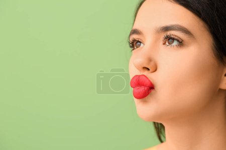 Téléchargez les photos : Belle jeune femme avec rouge à lèvres sur fond vert, gros plan - en image libre de droit