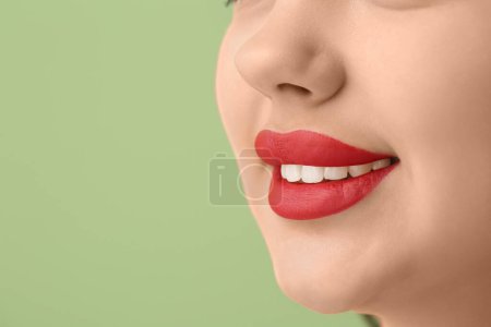 Téléchargez les photos : Jeune femme souriante avec rouge à lèvres rouge sur fond vert, gros plan - en image libre de droit