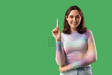 Téléchargez les photos : Jeune femme avec cigare électronique sur fond vert - en image libre de droit