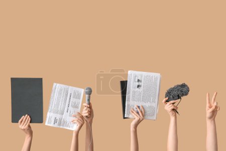 Téléchargez les photos : Mains féminines avec journaux, cahiers et microphones sur fond couleur - en image libre de droit