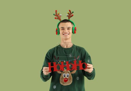 Téléchargez les photos : Adolescent garçon dans rennes cornes avec Noël salutation sur fond vert - en image libre de droit