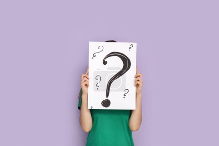 Photo for Young woman holding paper sheet with question marks on lilac background - Royalty Free Image