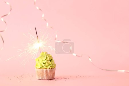 Photo for Tasty birthday cupcake with sparkler and decor on pink background - Royalty Free Image