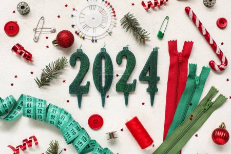 Téléchargez les photos : Composition avec figure 2024 faite de bougies, fournitures de couture et décorations de Noël sur fond clair - en image libre de droit