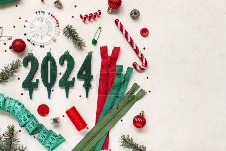 Foto de Composición con figura 2024 hecha de velas, suministros de costura y decoraciones navideñas sobre fondo claro - Imagen libre de derechos
