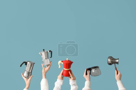 Photo for Female hands holding different coffee makers on blue background - Royalty Free Image