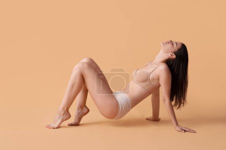 Body positive woman in underwear on beige background