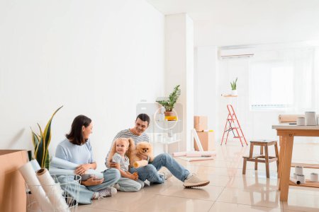 Téléchargez les photos : Famille heureuse avec des fournitures assis pendant la réparation de leur nouvelle maison - en image libre de droit