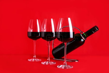 Téléchargez les photos : Bouteille et verres de vin rouge sur fond de couleur - en image libre de droit
