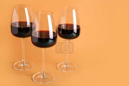 Téléchargez les photos : Lunettes de vin rouge sur fond orange - en image libre de droit