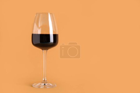Téléchargez les photos : Verre de vin rouge sur fond orange - en image libre de droit