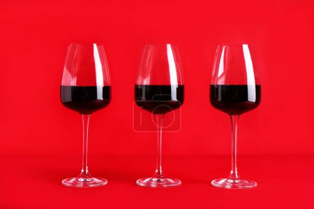 Téléchargez les photos : Lunettes de vin rouge sur fond de couleur - en image libre de droit