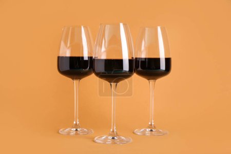 Téléchargez les photos : Lunettes de vin rouge sur fond orange - en image libre de droit