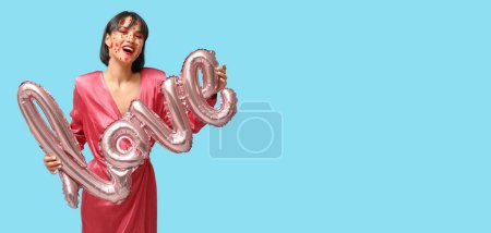 Photo for Stylish young woman with creative makeup for Valentines Day and balloon in shape of word LOVE on blue background with space for text - Royalty Free Image