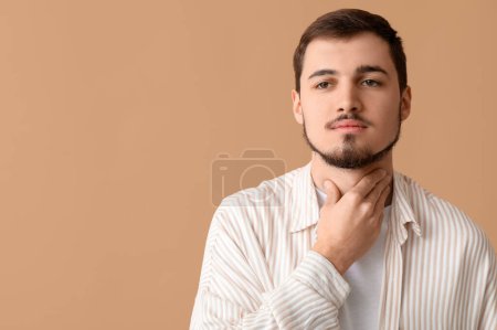 Photo for Young man with thyroid gland problem on beige background - Royalty Free Image