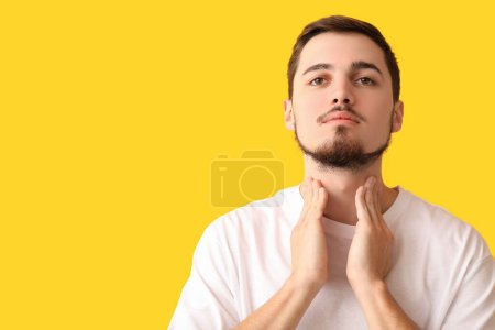 Photo for Young man with thyroid gland problem on yellow background - Royalty Free Image