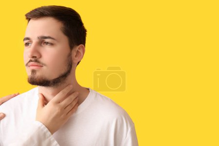 Photo for Endocrinologist examining thyroid gland of young man on yellow background - Royalty Free Image