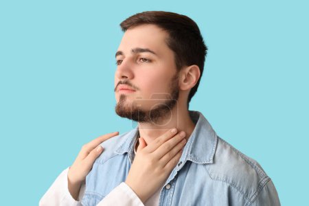 Photo for Endocrinologist examining thyroid gland of young man on blue background - Royalty Free Image