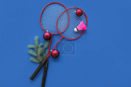 Photo for Badminton rackets with shuttlecock and Christmas decor on blue background - Royalty Free Image