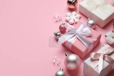 Komposition mit Geschenken und Weihnachtsdekor auf rosa Hintergrund