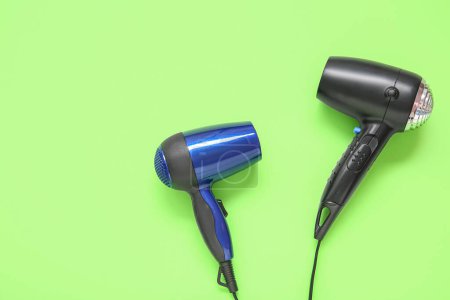 Photo for Hair dryers on green background, top view - Royalty Free Image