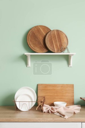Foto de Placas de encimera de madera en cesta y tablas de cortar en estante - Imagen libre de derechos