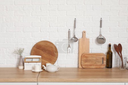 Foto de Mostradores de madera con tablas de cortar y utensilios en la cocina moderna - Imagen libre de derechos