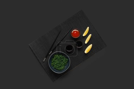 Foto de Composición con algas sanas, salsas y palillos sobre fondo oscuro - Imagen libre de derechos