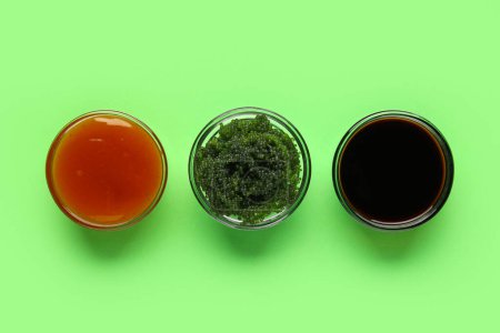 Foto de Cuencos con algas sanas y salsas sobre fondo verde - Imagen libre de derechos