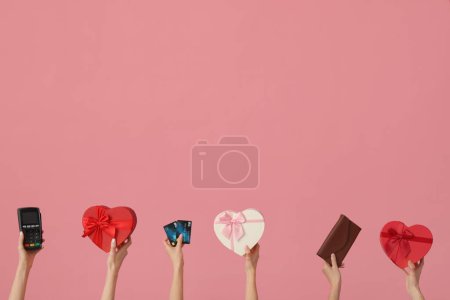 Femmes avec terminal de paiement, cadeaux, cartes de crédit et portefeuille sur fond rose. Fête de la Saint-Valentin