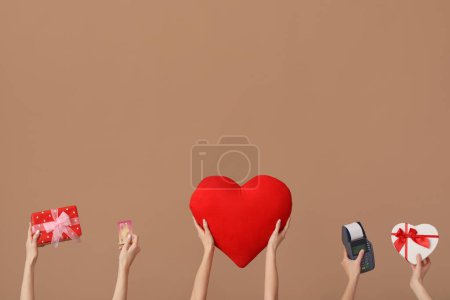Les femmes avec des cadeaux, carte de crédit, terminal de paiement et coeur sur fond brun. Fête de la Saint-Valentin