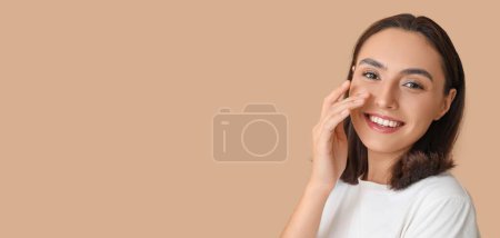 Téléchargez les photos : Young woman touching her nose on beige background with space for text - en image libre de droit