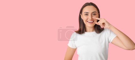 Téléchargez les photos : Young woman pointing at her nose on pink background with space for text - en image libre de droit