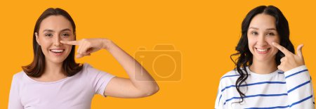 Téléchargez les photos : Jeunes femmes montrant leur nez sur fond jaune avec espace pour le texte - en image libre de droit