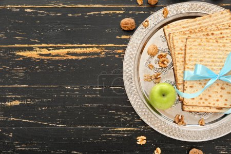 Photo for Passover Seder plate with flatbread matza, apple and walnuts on dark wooden background - Royalty Free Image